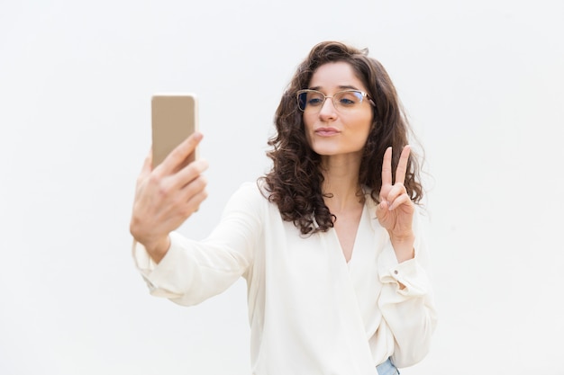 Chica alegre mujer tomando selfie en smartphone