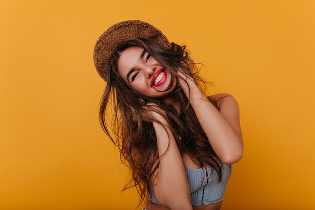 Chica alegre de pelo largo con maquillaje de moda disfrutando de un buen día y una sonrisa feliz