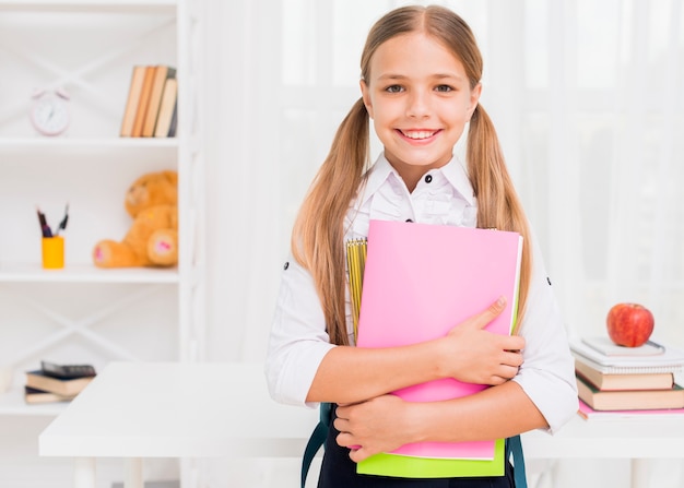 Chica alegre sonriendo con libros