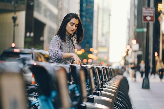 Chica alquilando una bicicleta de ciudad en un puesto de bicicletas.