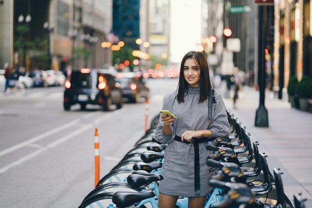 Chica alquilando una bicicleta de ciudad en un puesto de bicicletas.