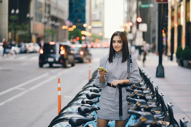 Chica alquilando una bicicleta de ciudad en un puesto de bicicletas.