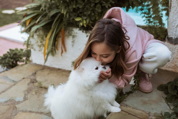 Chica de alta vista besando a su perro