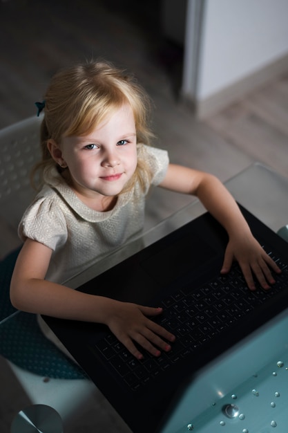 Chica de alto ángulo en computadora jugando