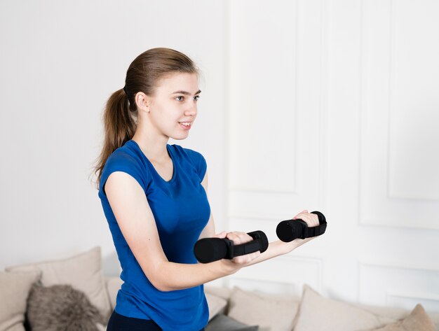 Chica de alto ángulo de entrenamiento con pesas