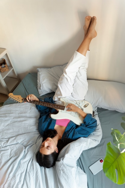 Chica de alto ángulo haciendo música en el interior