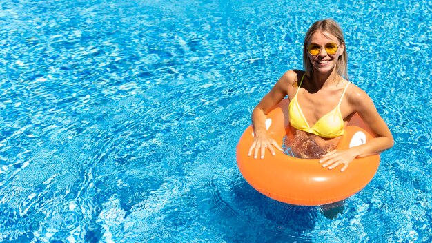 Chica de alto ángulo posando en la piscina