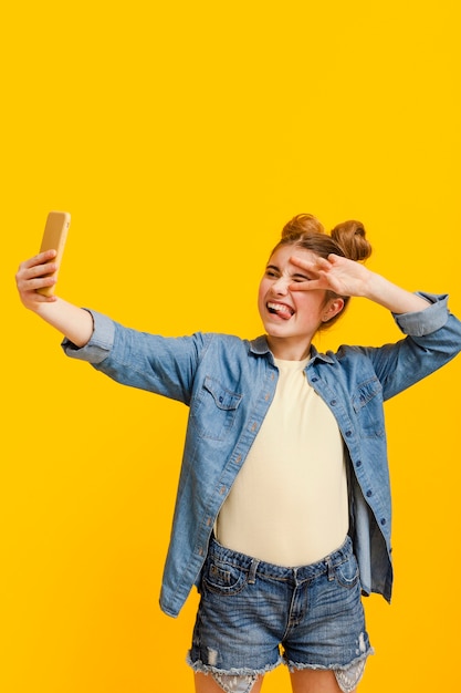 Chica de alto ángulo tomando selfie