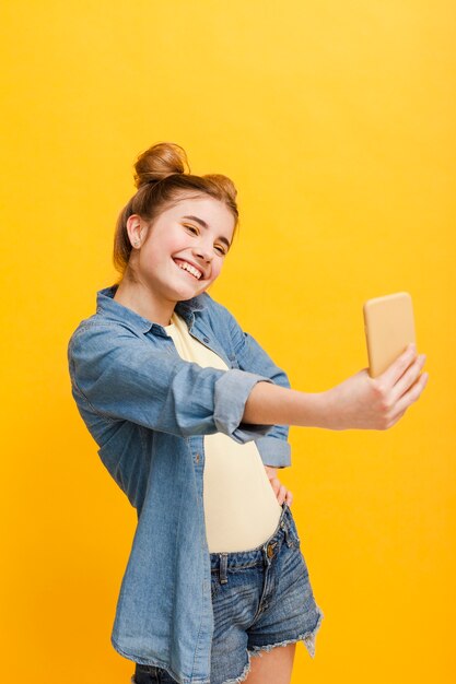 Chica de alto ángulo tomando selfie