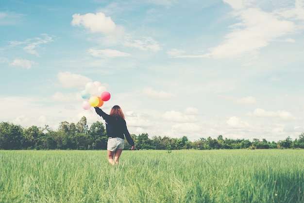 Chica andando con globos de colores