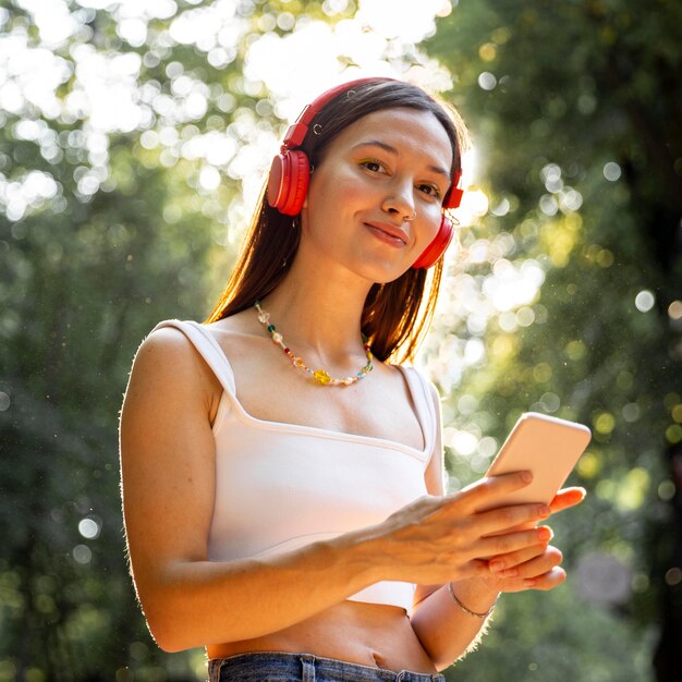 Chica de ángulo bajo con auriculares