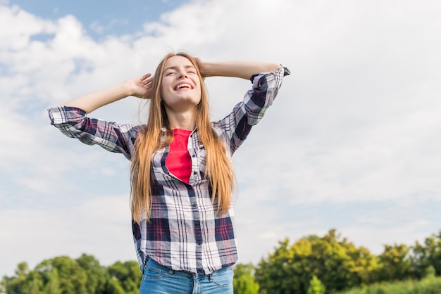 Chica de ángulo bajo disfrutando de un día soleado