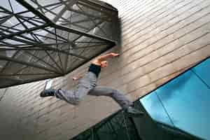 Foto gratuita chica de ángulo bajo haciendo entrenamiento de parkour