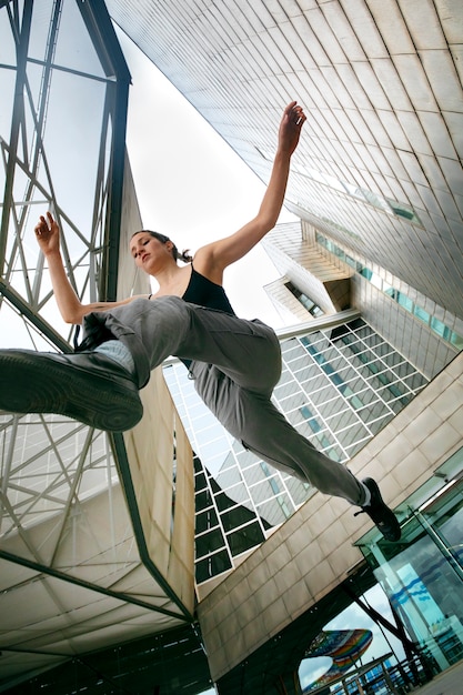 Chica de ángulo bajo haciendo entrenamiento de parkour