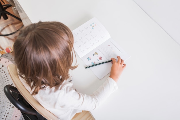 Foto gratuita chica anónima haciendo la tarea