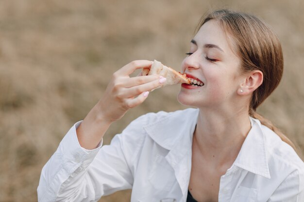 Chica apetitosa comiendo pizza