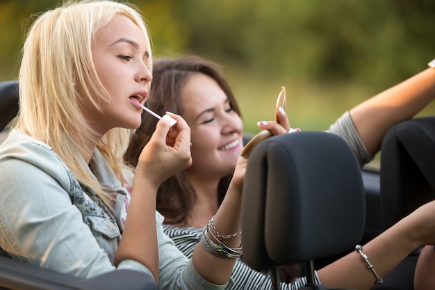 Chica aplicándose brillo de labios en el coche