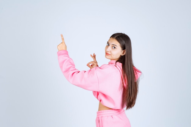 Chica apuntando hacia el lado izquierdo con emociones en su rostro