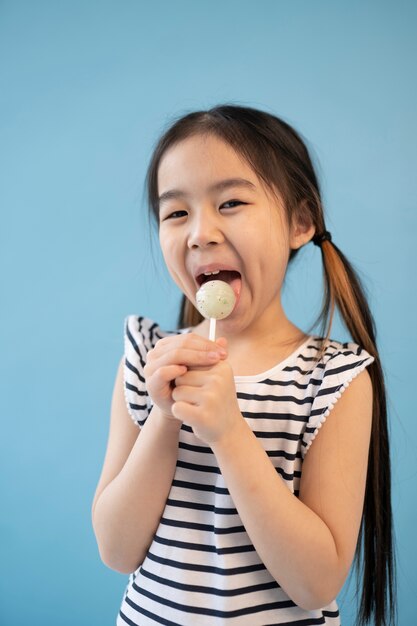 Chica asiática comiendo una piruleta