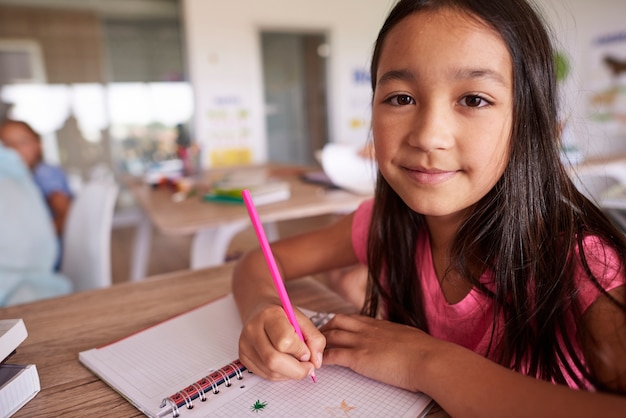 Chica asiática creando en su cuaderno