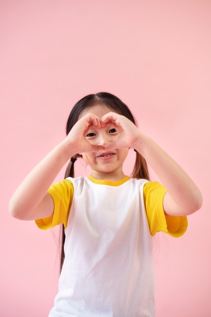 Chica asiática haciendo el signo del corazón con las manos