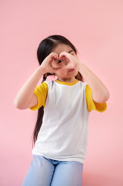 Chica asiática haciendo el signo del corazón con las manos