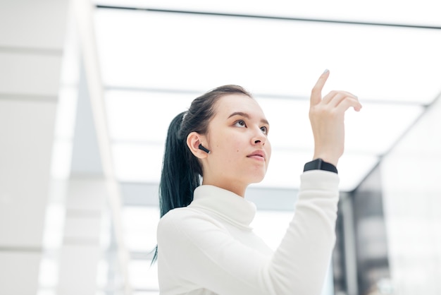 Chica asiática tocando la tecnología futurista de pantalla virtual