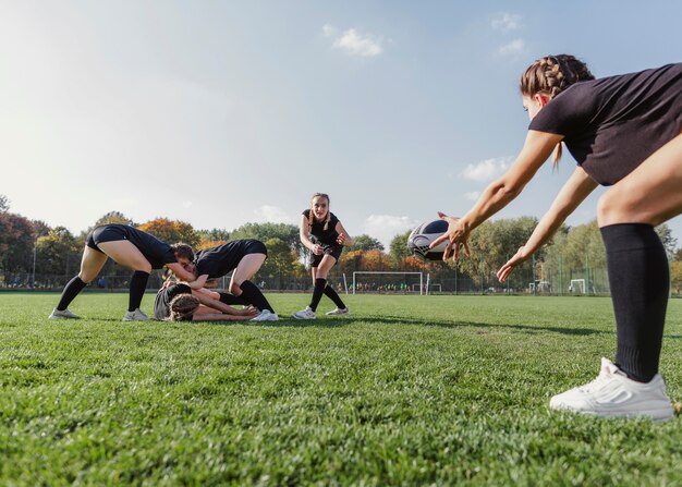 Chica atlética tratando de atrapar una pelota de rugby