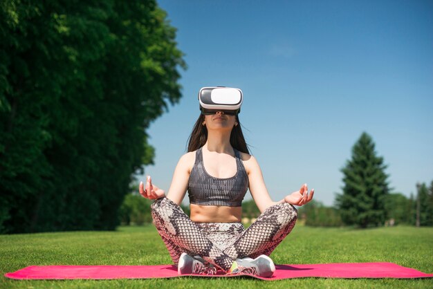 Chica atlético usando unas gafas de realidad virtual al aire libre