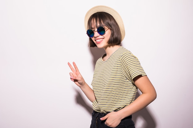 Chica atractiva adolescente hipster con sombrero, gafas de sol aislado