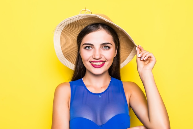 Foto gratuita chica atractiva en un bikini blanco, sombrero, gafas de sol, emocionalmente abrió la boca en una pared amarilla con un cuerpo perfecto. aislado.