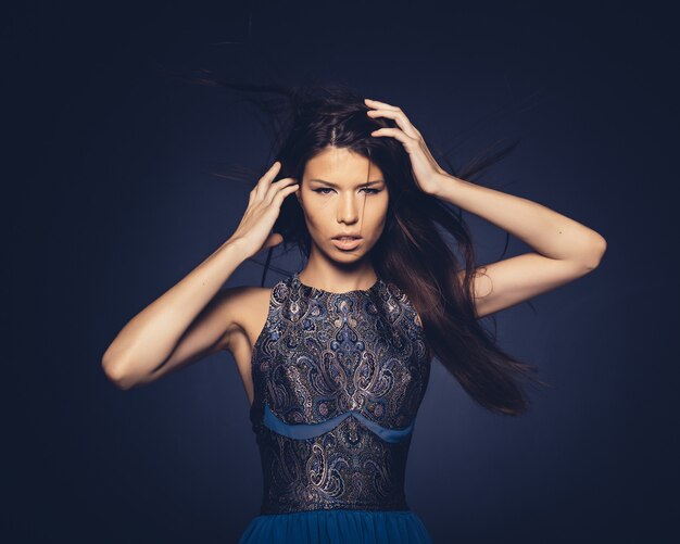 Chica atractiva con cabello volando posando en studio