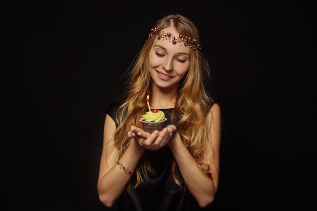 Chica atractiva con una corona y cupcake