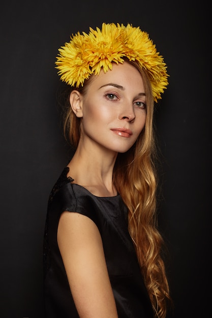 Chica atractiva con una corona de flores en la cabeza