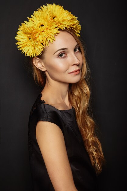 Chica atractiva con una corona de flores en la cabeza