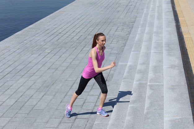 Chica atractiva corriendo en la calle