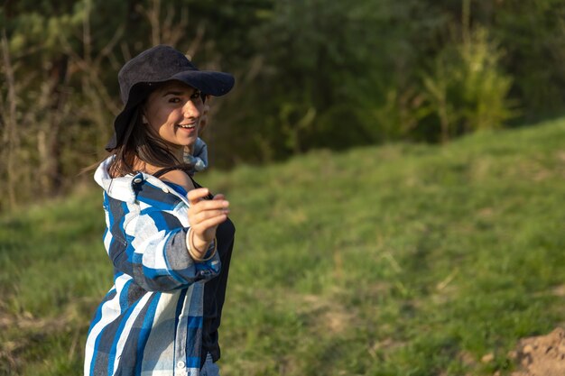 Chica atractiva en un paseo por el bosque de la primavera en estilo casual.