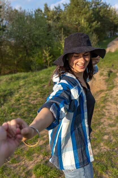 Chica atractiva en un paseo por el bosque de la primavera en estilo casual