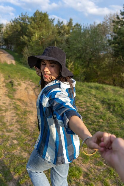 Chica atractiva en un paseo por el bosque de la primavera en estilo casual