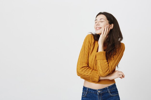 Chica atractiva romántica soñando despierto, cerrar los ojos y sonriendo feliz