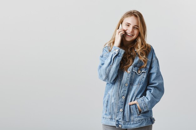 Chica atractiva sonriente hablando por teléfono con cara feliz