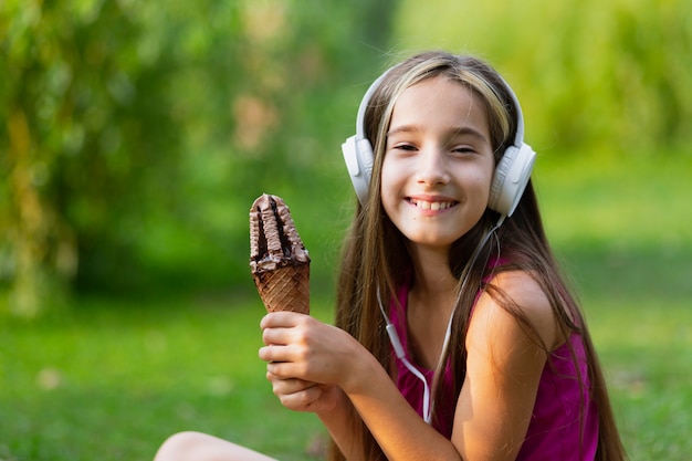 Chica con auriculares blancos y helado de chocolate