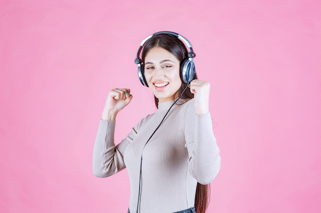 Chica con auriculares escuchando música y sintiéndose feliz