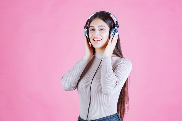 Chica con auriculares escuchando música y sintiéndose feliz