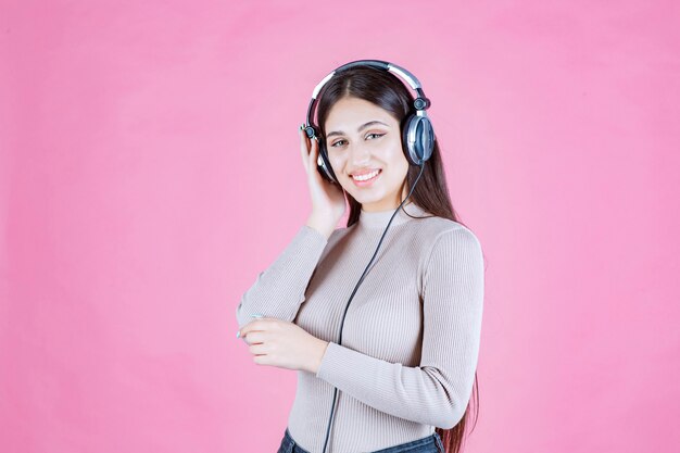 Chica con auriculares escuchando música y sintiéndose feliz