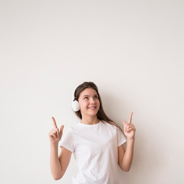 Chica con auriculares señalando