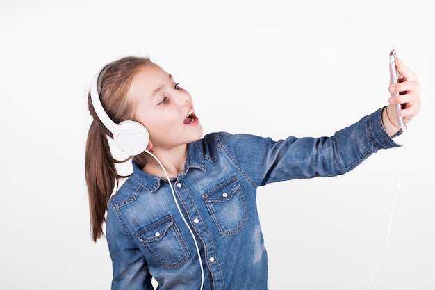 Foto gratuita chica en auriculares tomando selfie