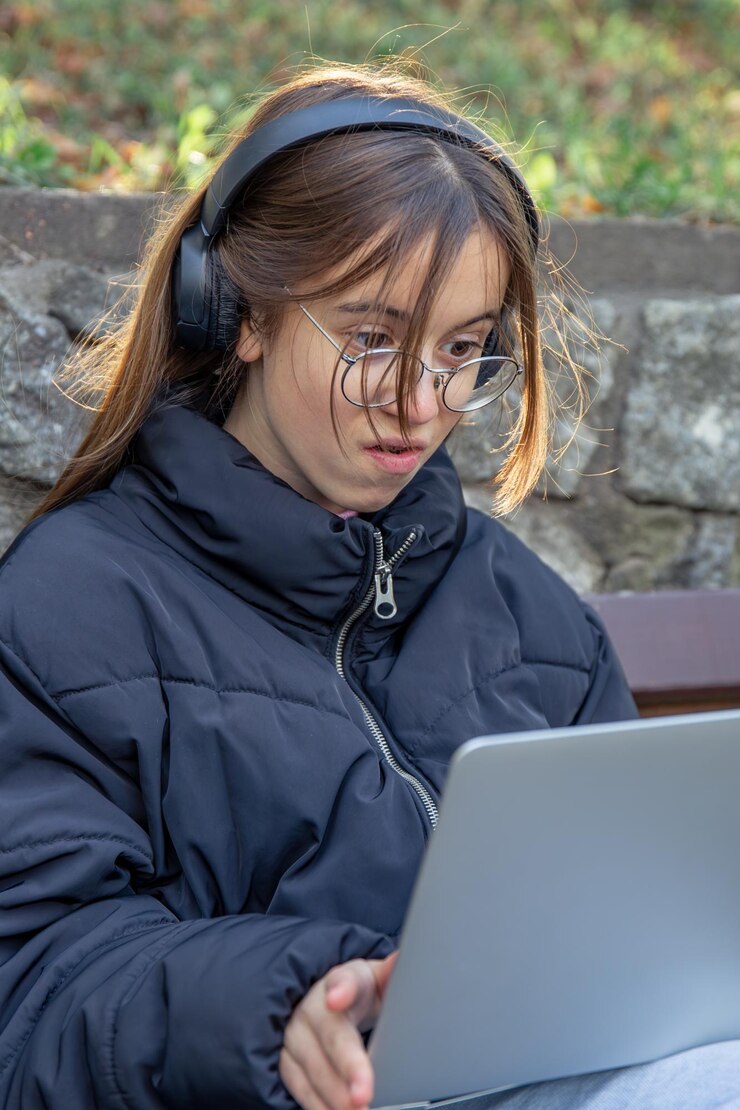 Foto gratuito una chica con auriculares trabaja en un portátil una chica con un portátil