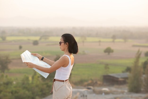 Chica aventurera navegando con un mapa topográfico en las hermosas montañas.