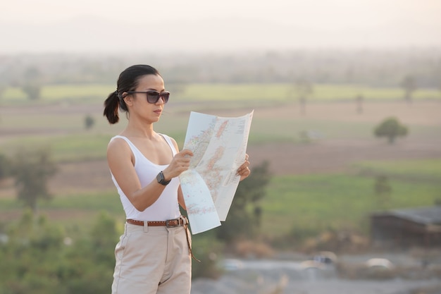 Chica aventurera navegando con un mapa topográfico en las hermosas montañas.